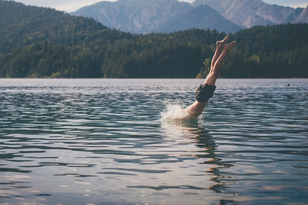 Mann springt kopfüber in einen See