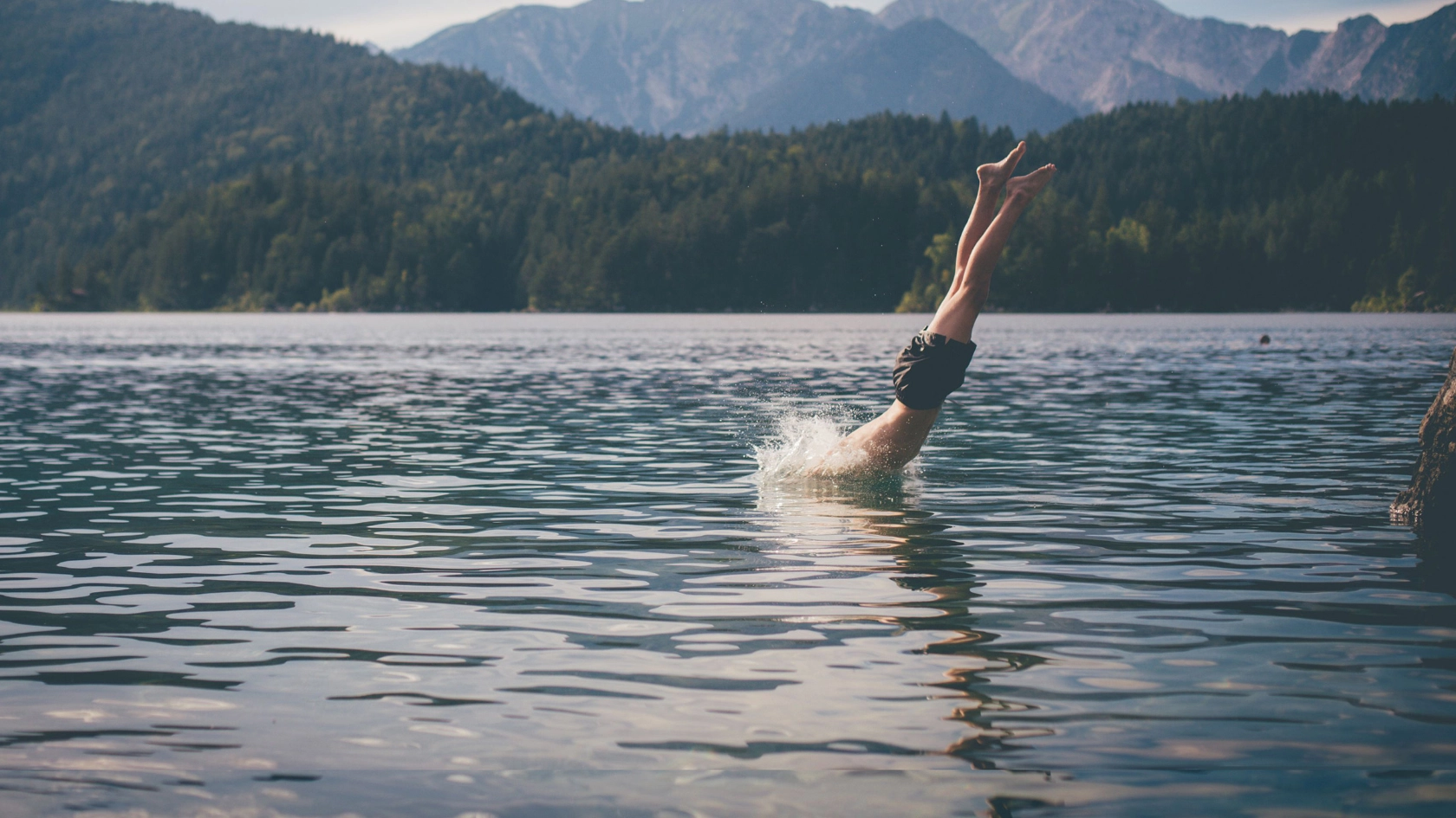 Mann springt kopfüber in einen See